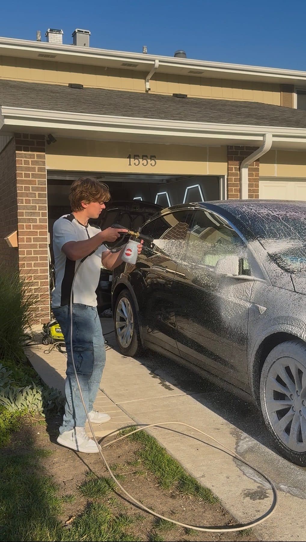 Foam-cannon pre-soak on a customer's Tesla during a mobile detail